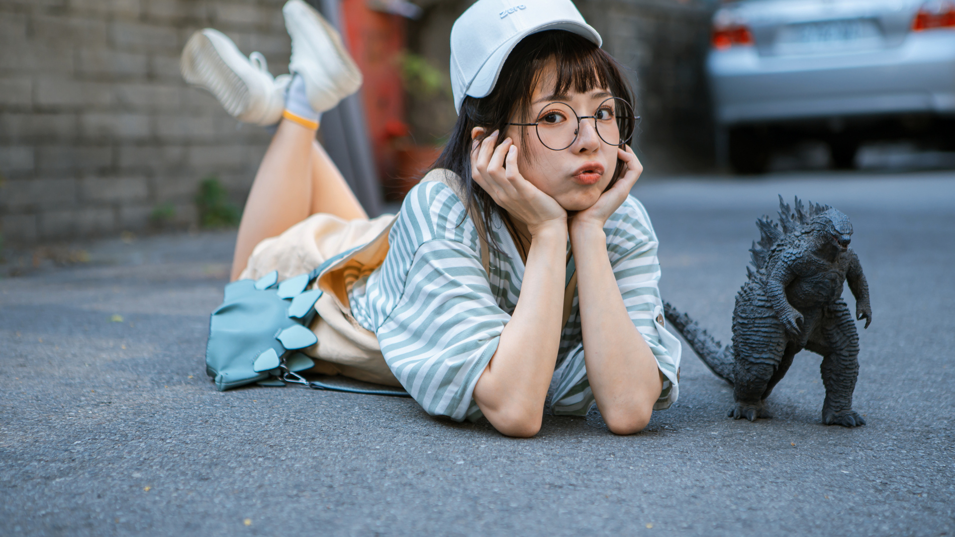 Девушка азиатка с фигуркой годзиллы