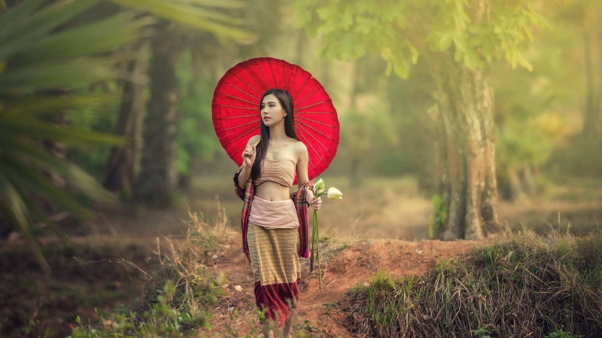 Девушка азиатка с красным зонтом и цветами лотоса