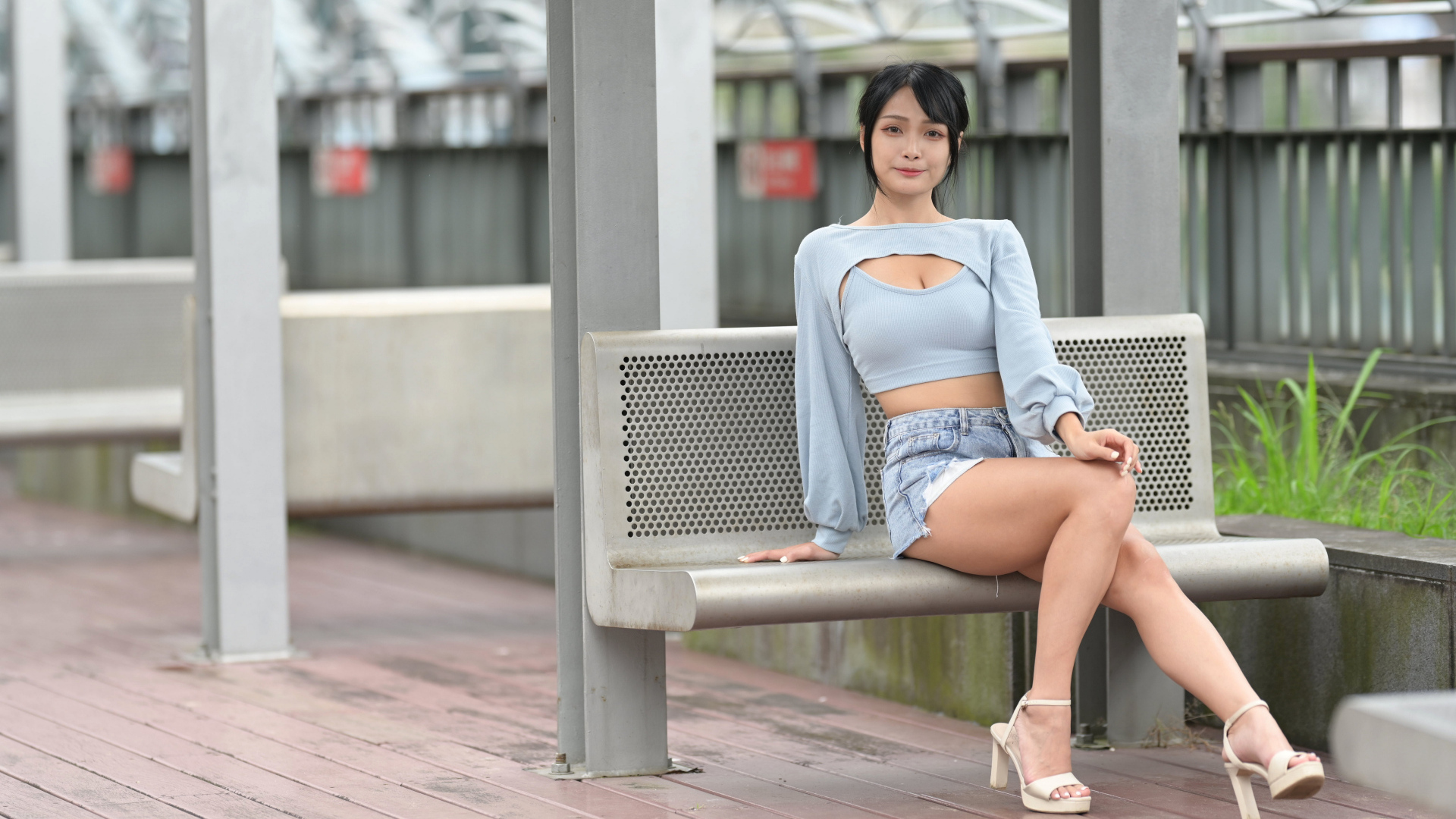 Красивая темноволосая девушка азиатка сидит на лавке