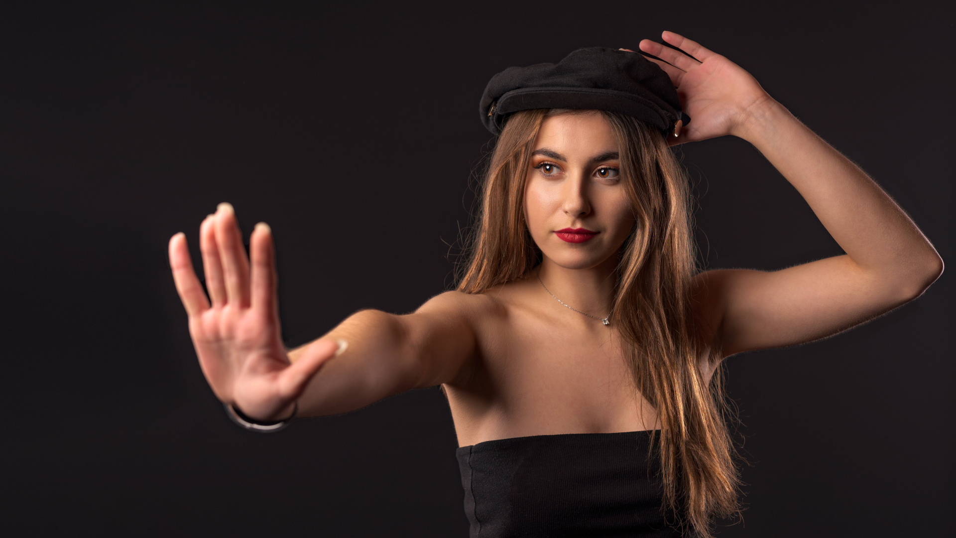 Красивая девушка в кепке на черном фоне