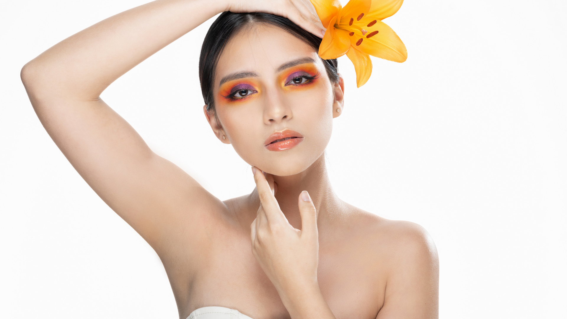 Красивая девушка с цветком лилии в волосах на белом фоне