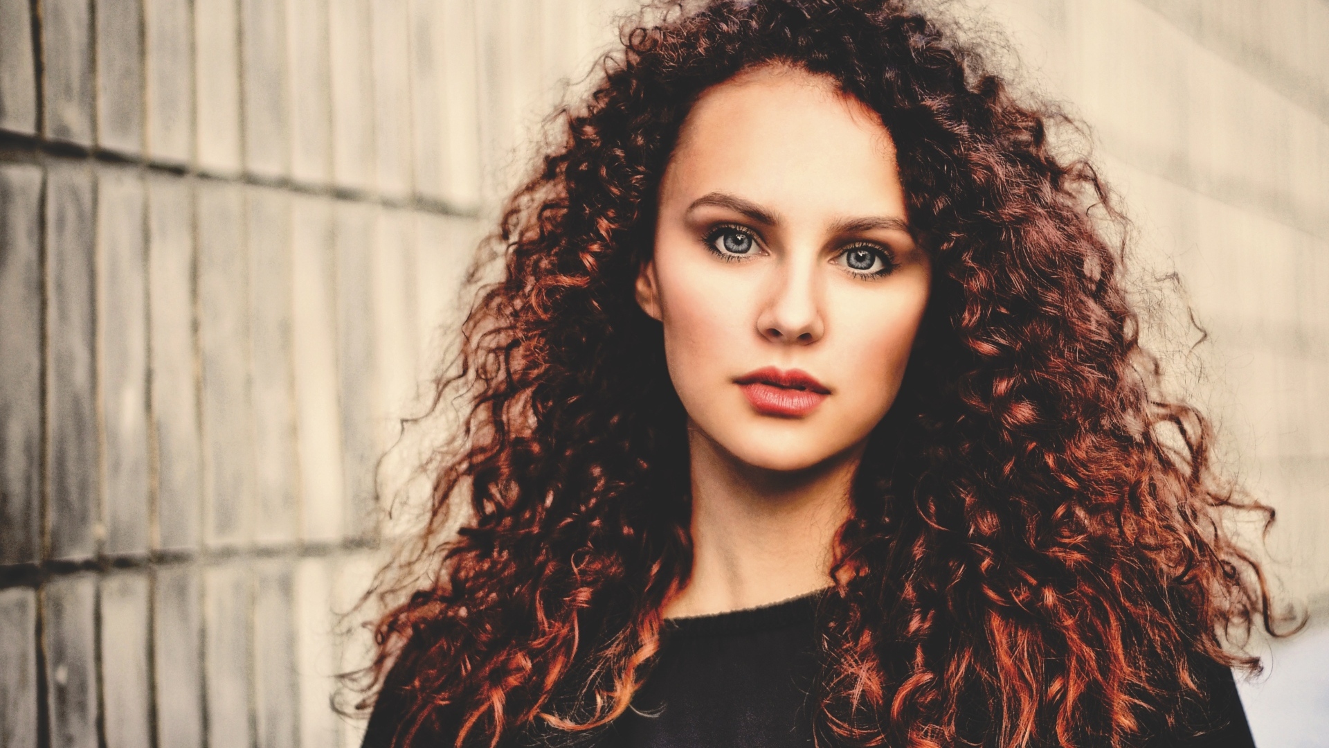 Кудрявые красивые волосы у девушки с серыми глазами