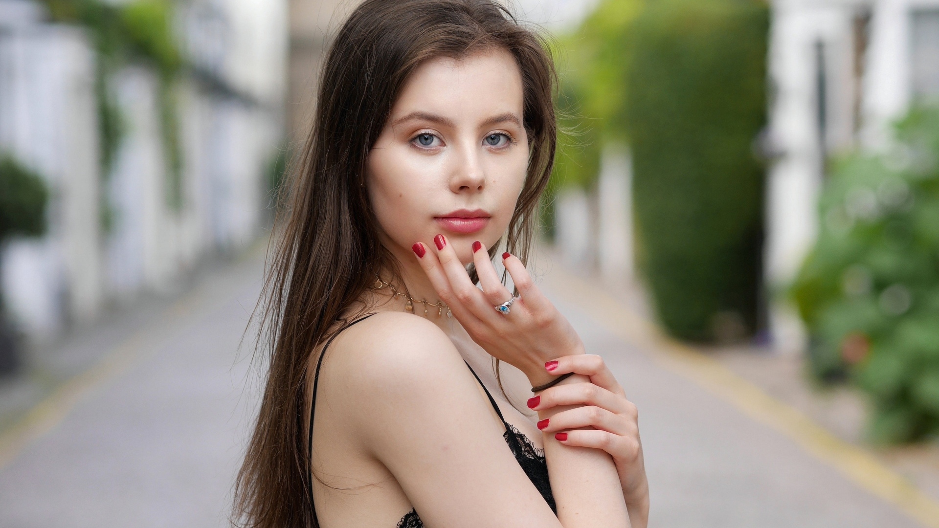 Милая голубоглазая девушка с красным маникюром