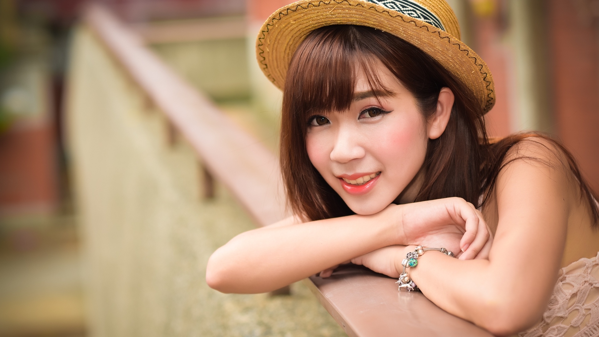 Милая улыбка азиатки в соломенной шляпе 