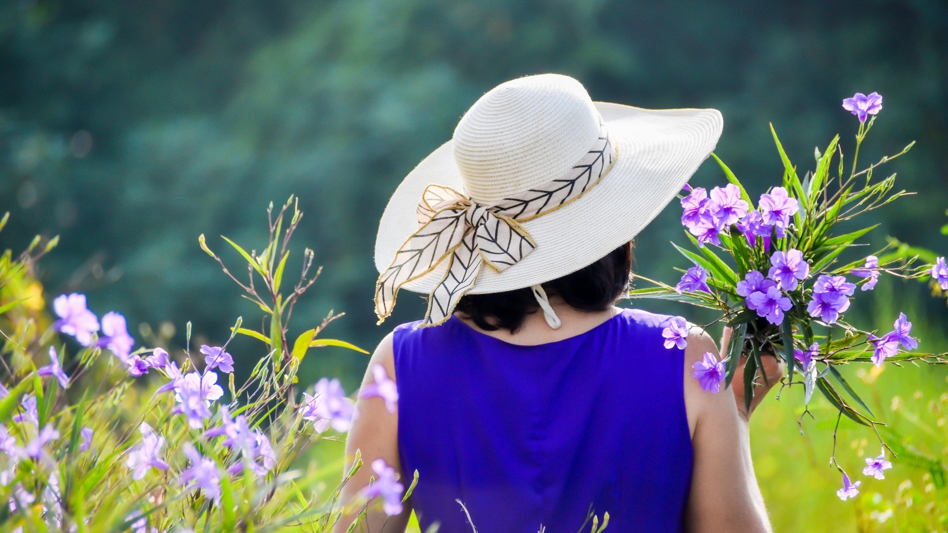 Девушка в шляпе с букетом полевых цветов