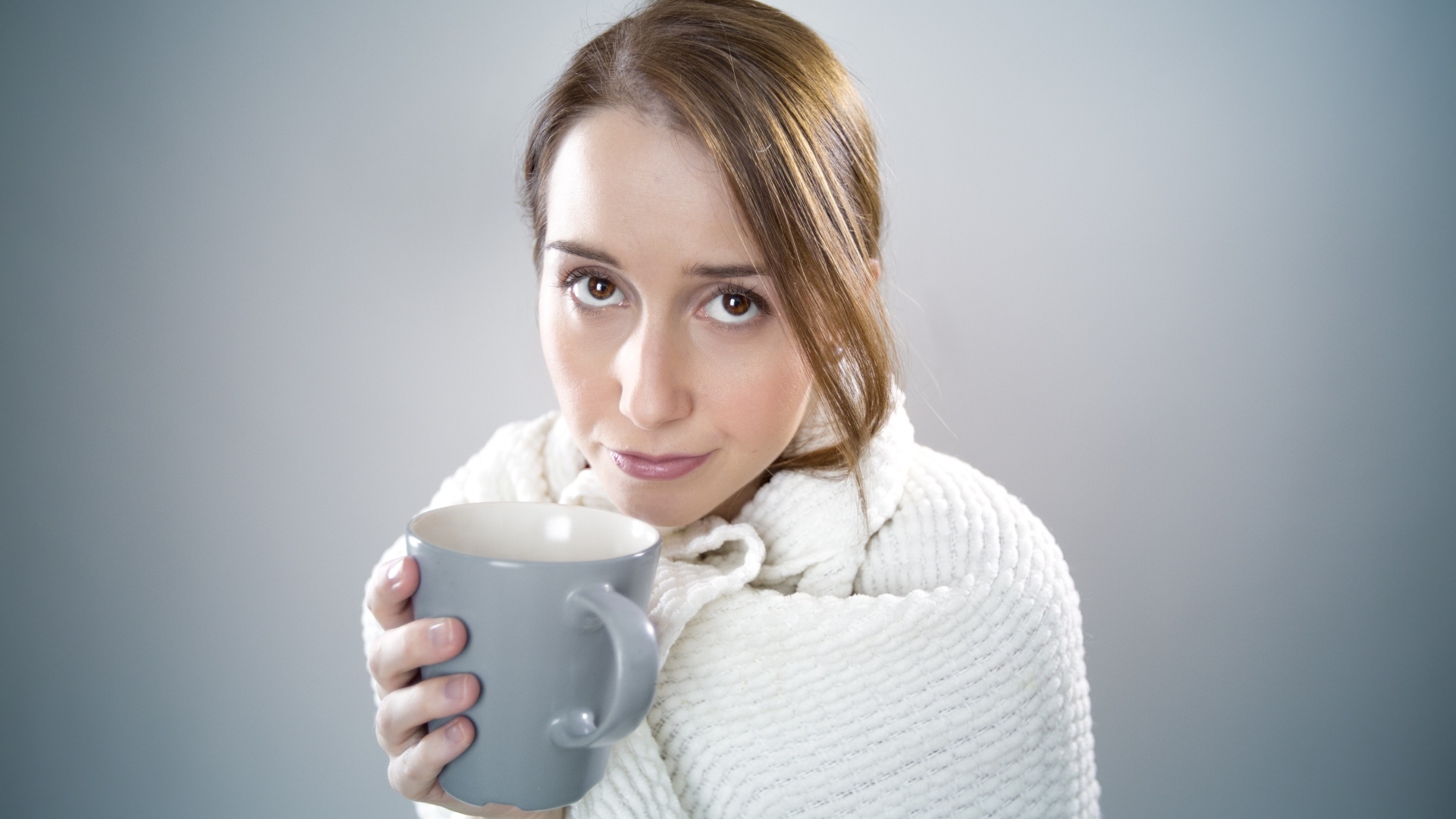 Девушка в белой кофте с кружкой в руке
