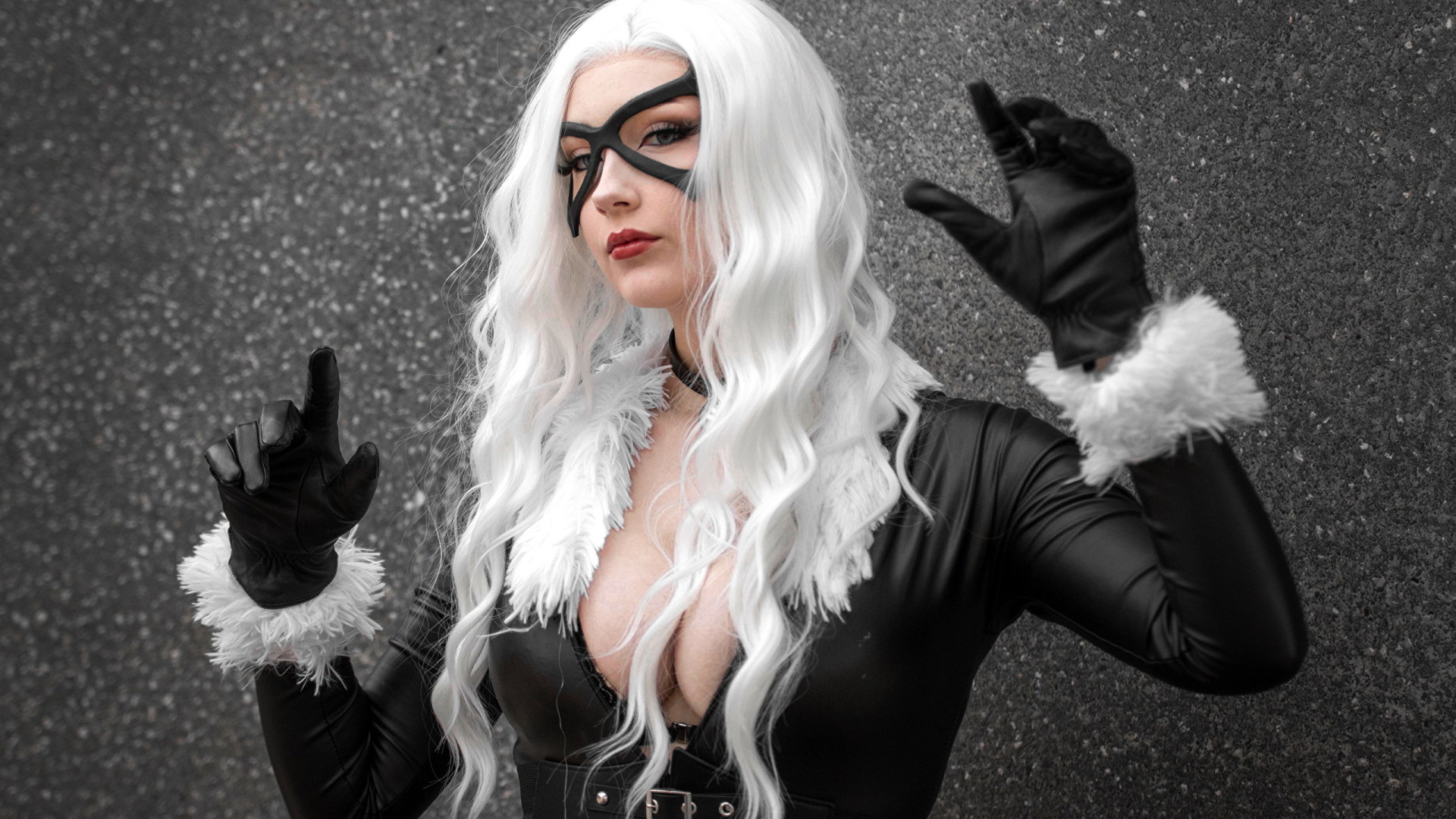 Девушка в белом парике в черном костюме у серой стены