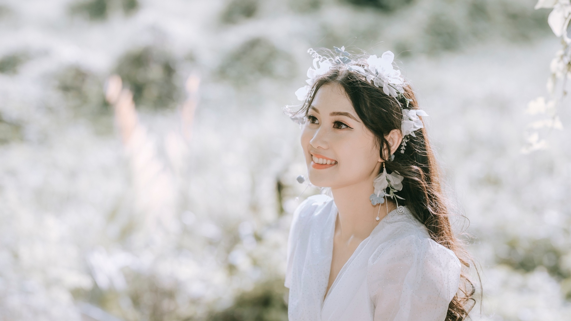 Улыбающаяся девушка азиатка в белом платье 