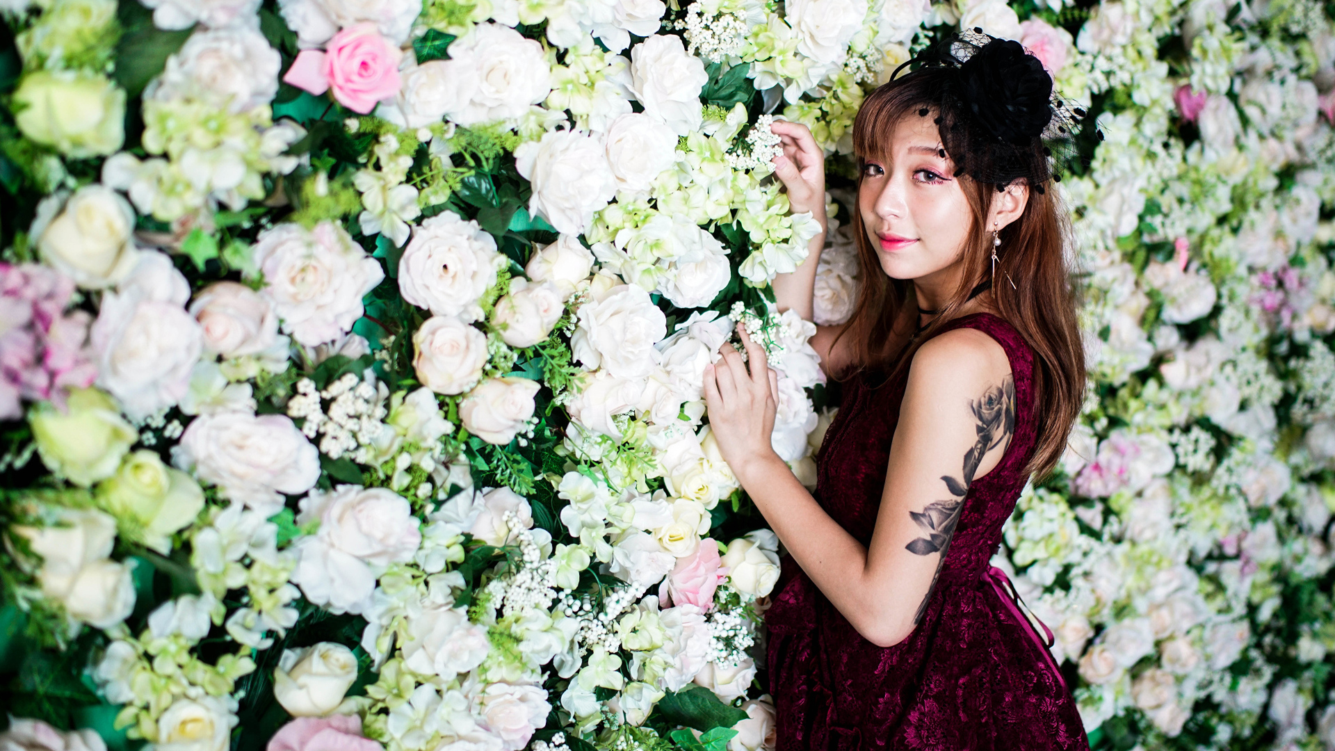 Молодая азиатка на фоне стены с розами