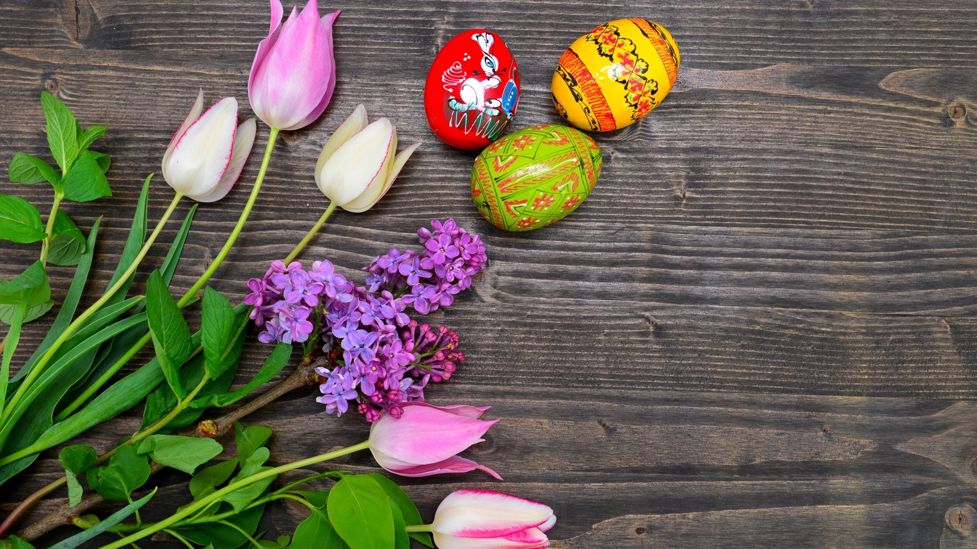 Пасхальные яйца с живыми цветами на столе 