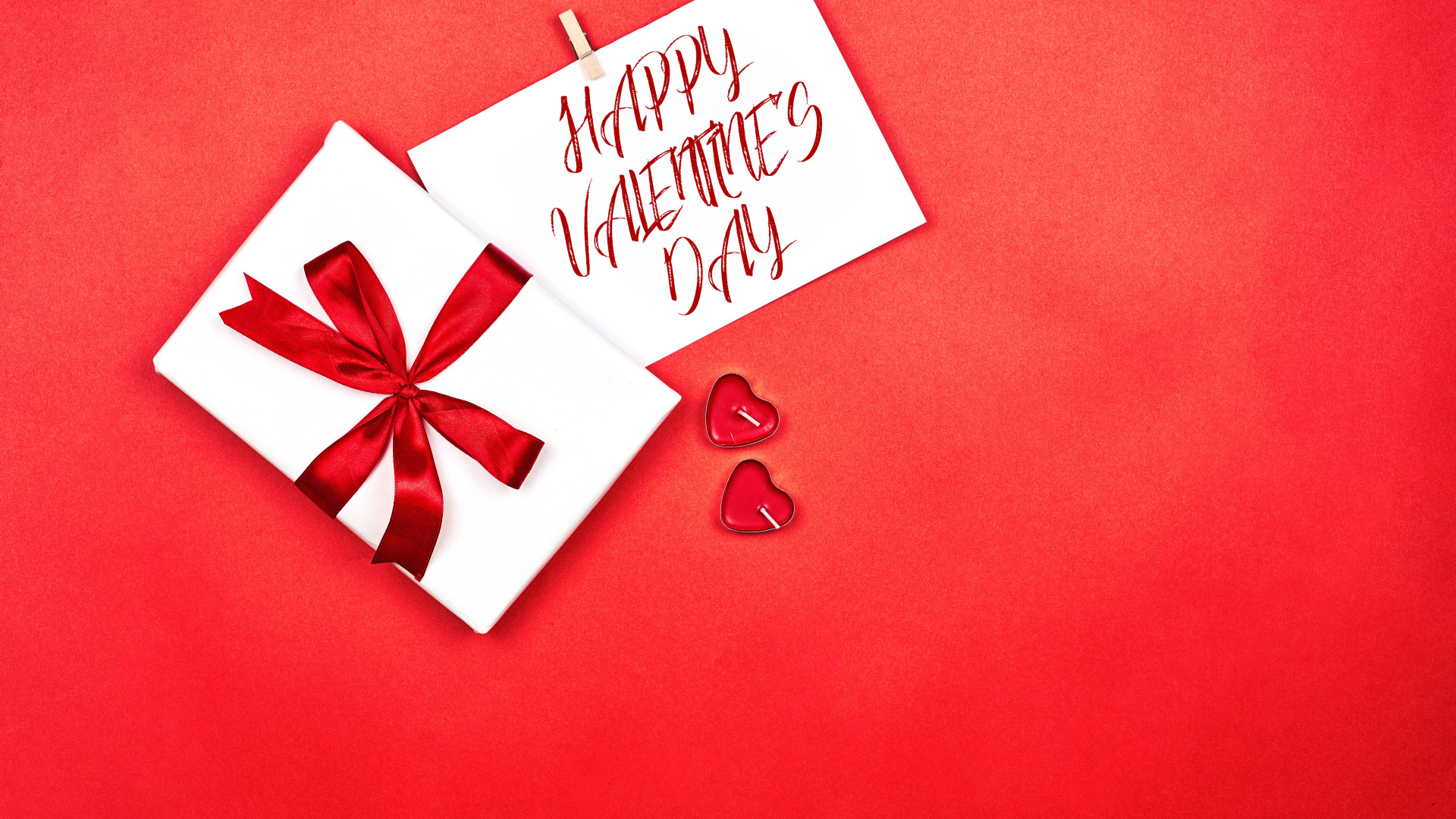 Открытка и подарок на красном фоне на День Святого Валентина