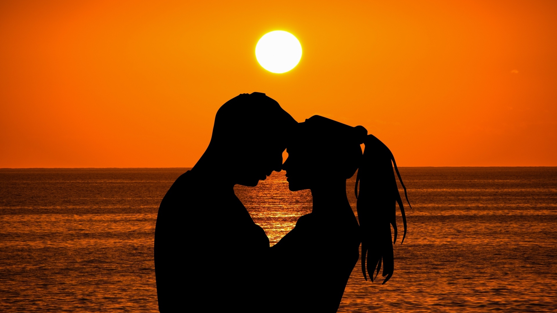 Влюбленная пара на закате солнца у моря
