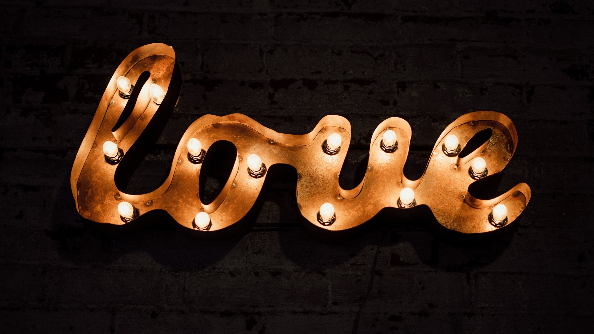 Светящаяся надпись любовь на черной стене