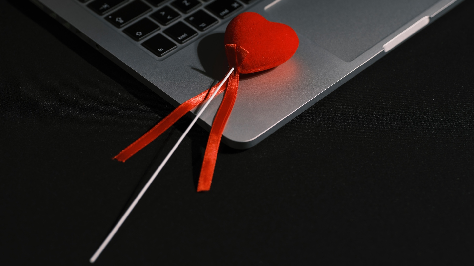 Красное сердце на палочке с ноутбуком