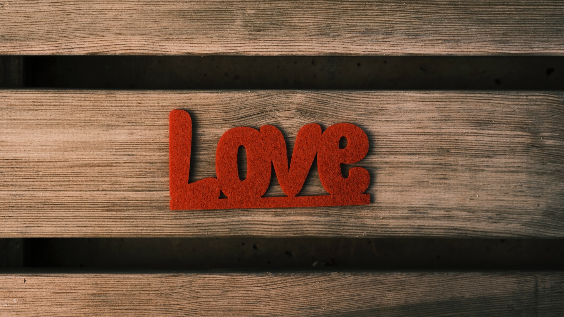 Красная надпись любовь на деревянном фоне