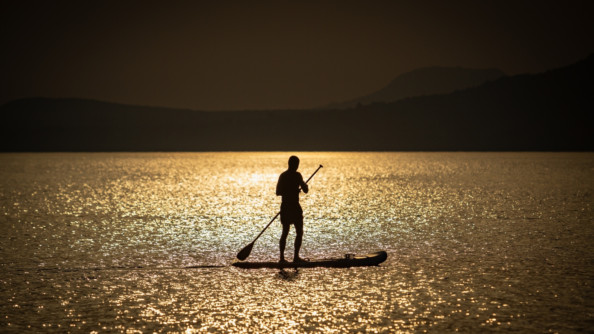Мужчина серфингист в море на закате