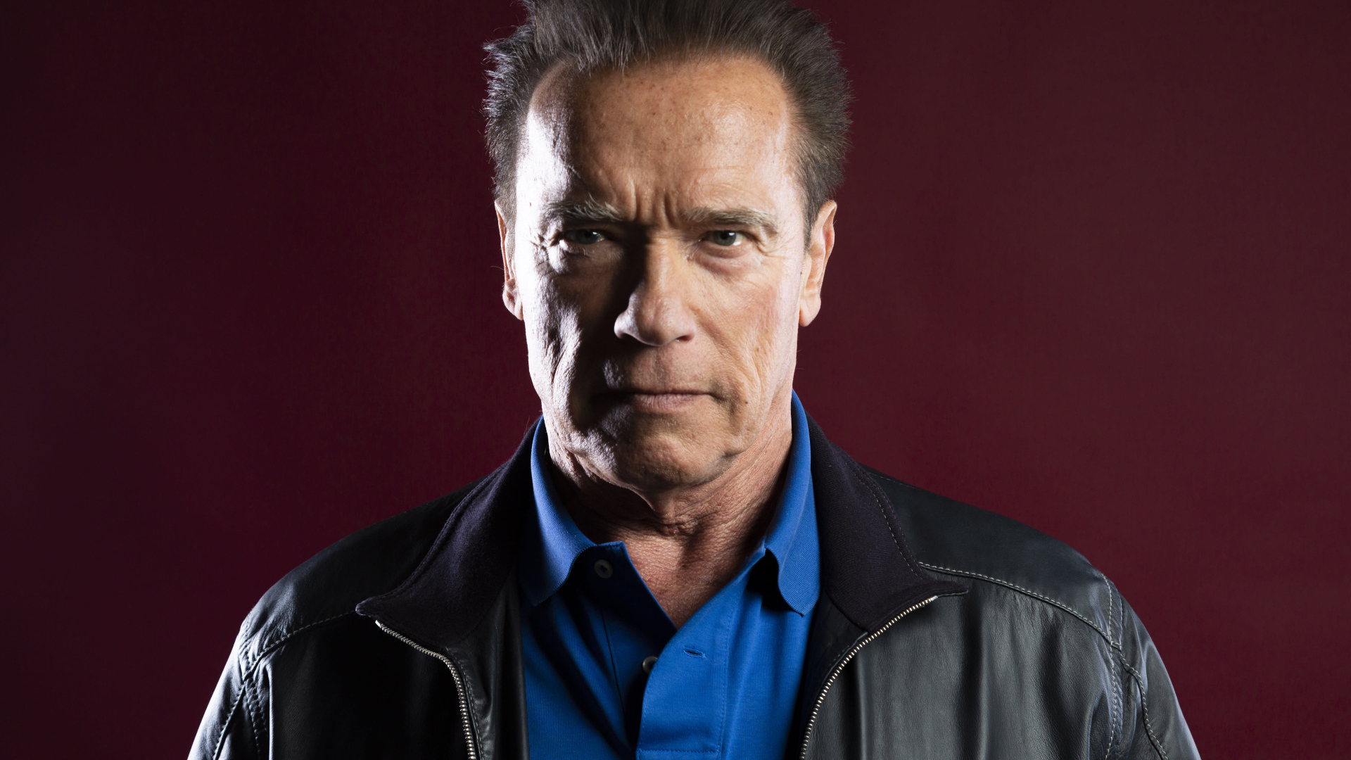 Популярный актер Арнольд Шварценеггер на красном фоне