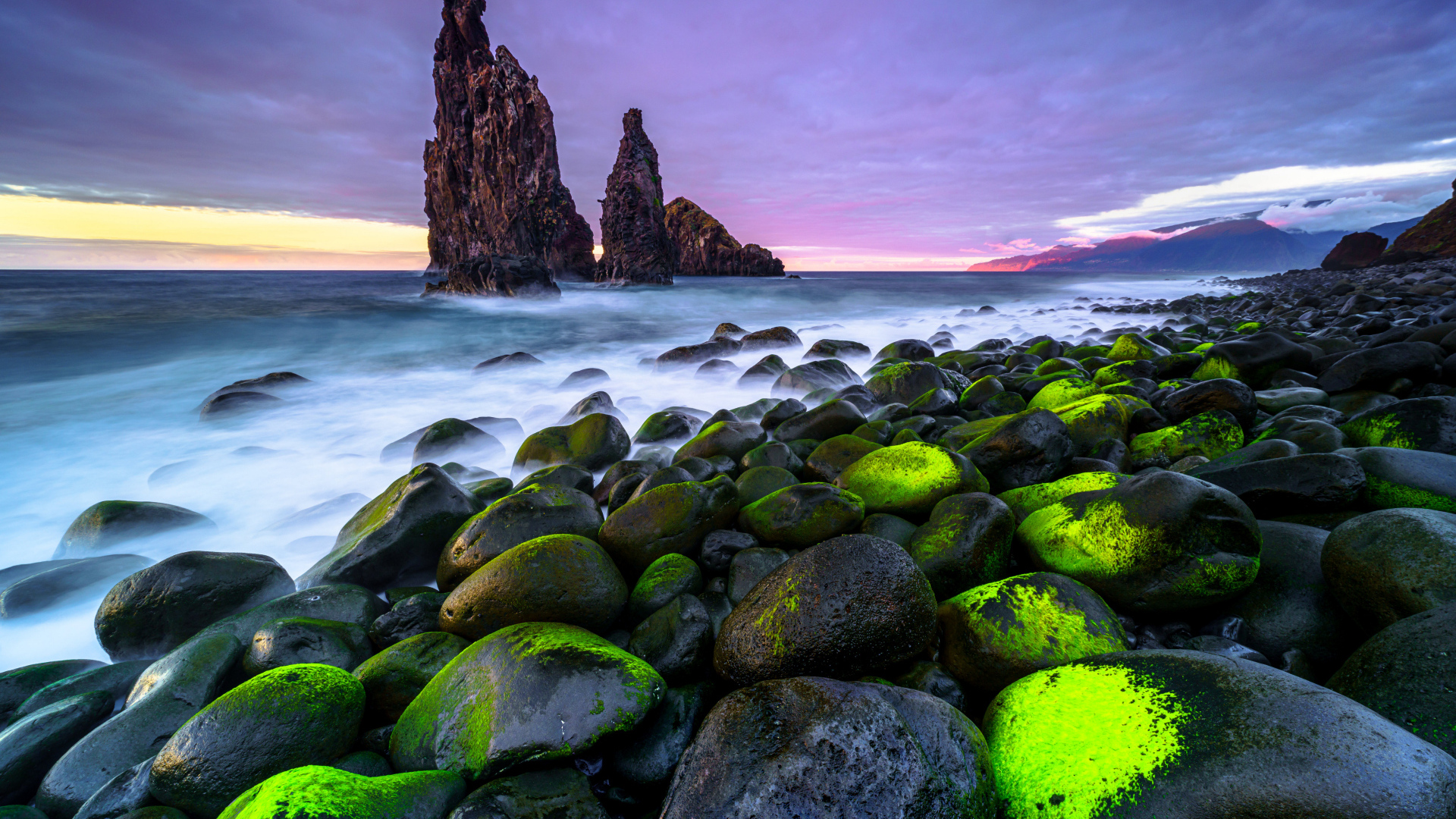 Большие черные камни лежат на берегу острова Мадейра