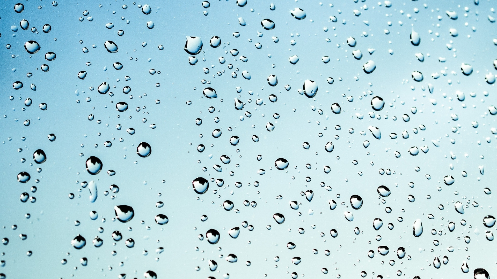Капли дождя на голубом стекле