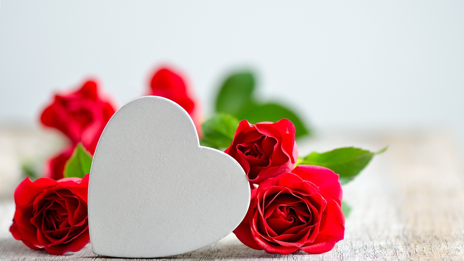 Красные розы с белым сердцем на столе