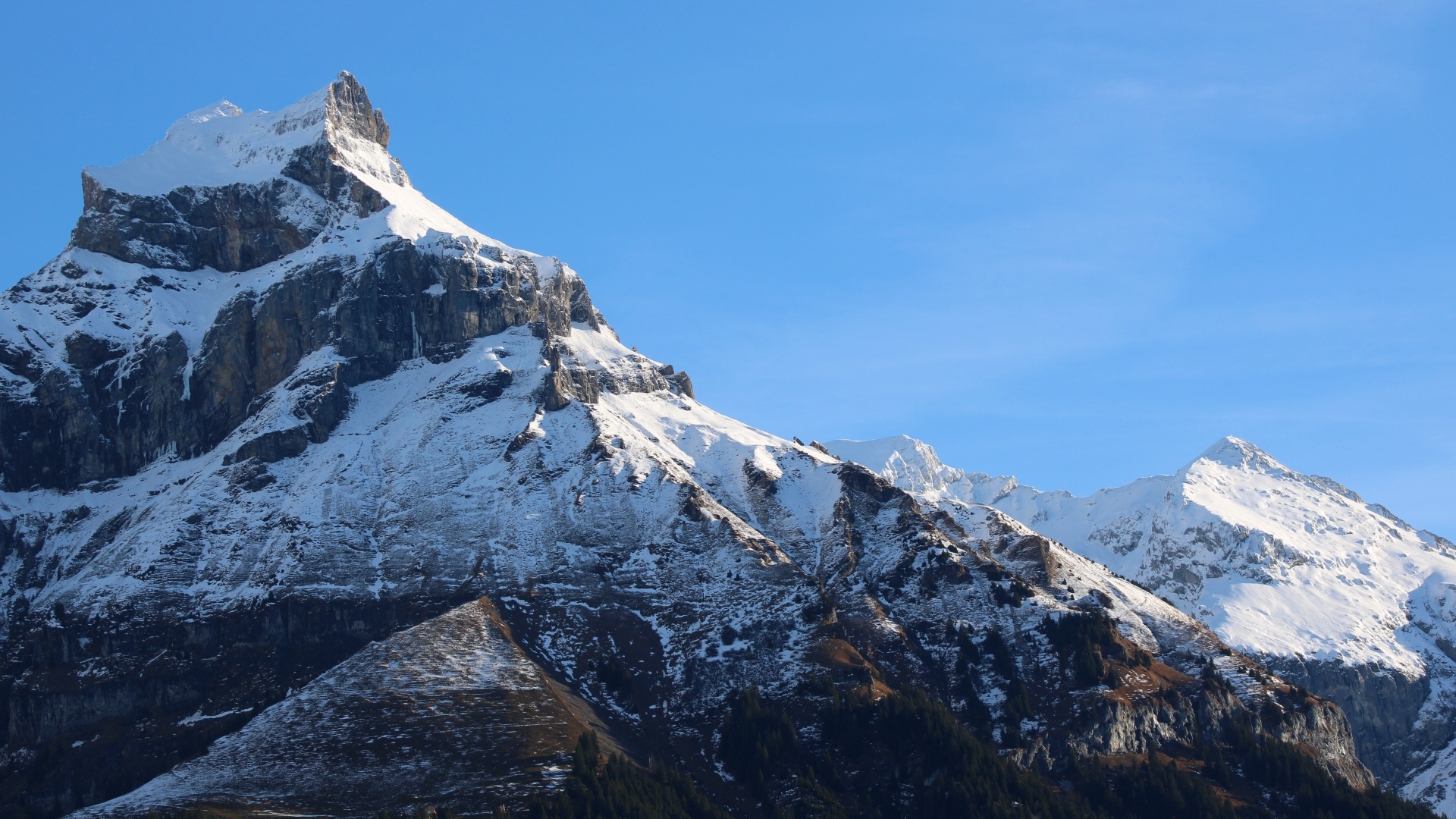 Вершина горы покрыта снегом в лучах солнца