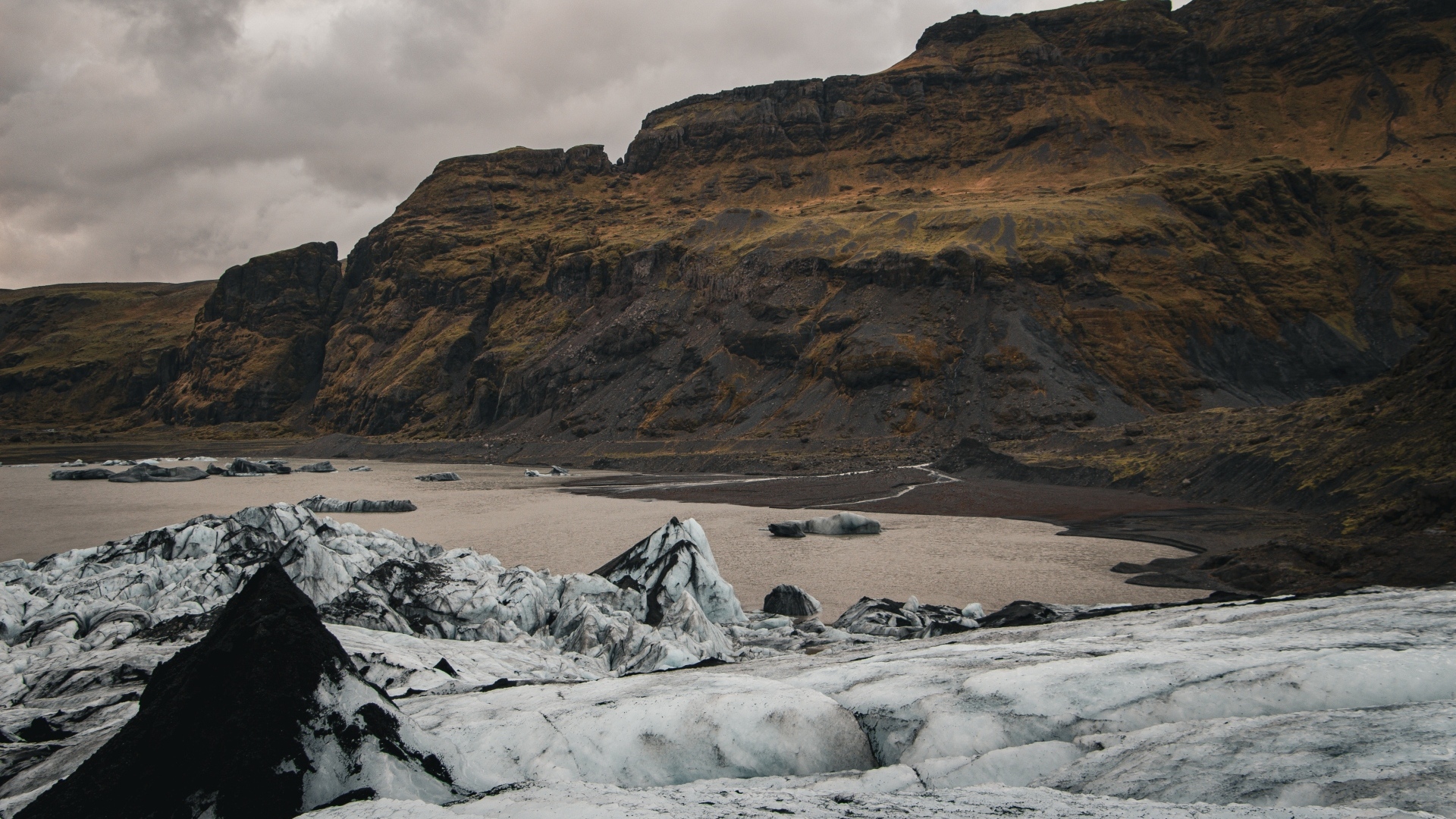 Холодный грязный снег на берегу моря у гор 