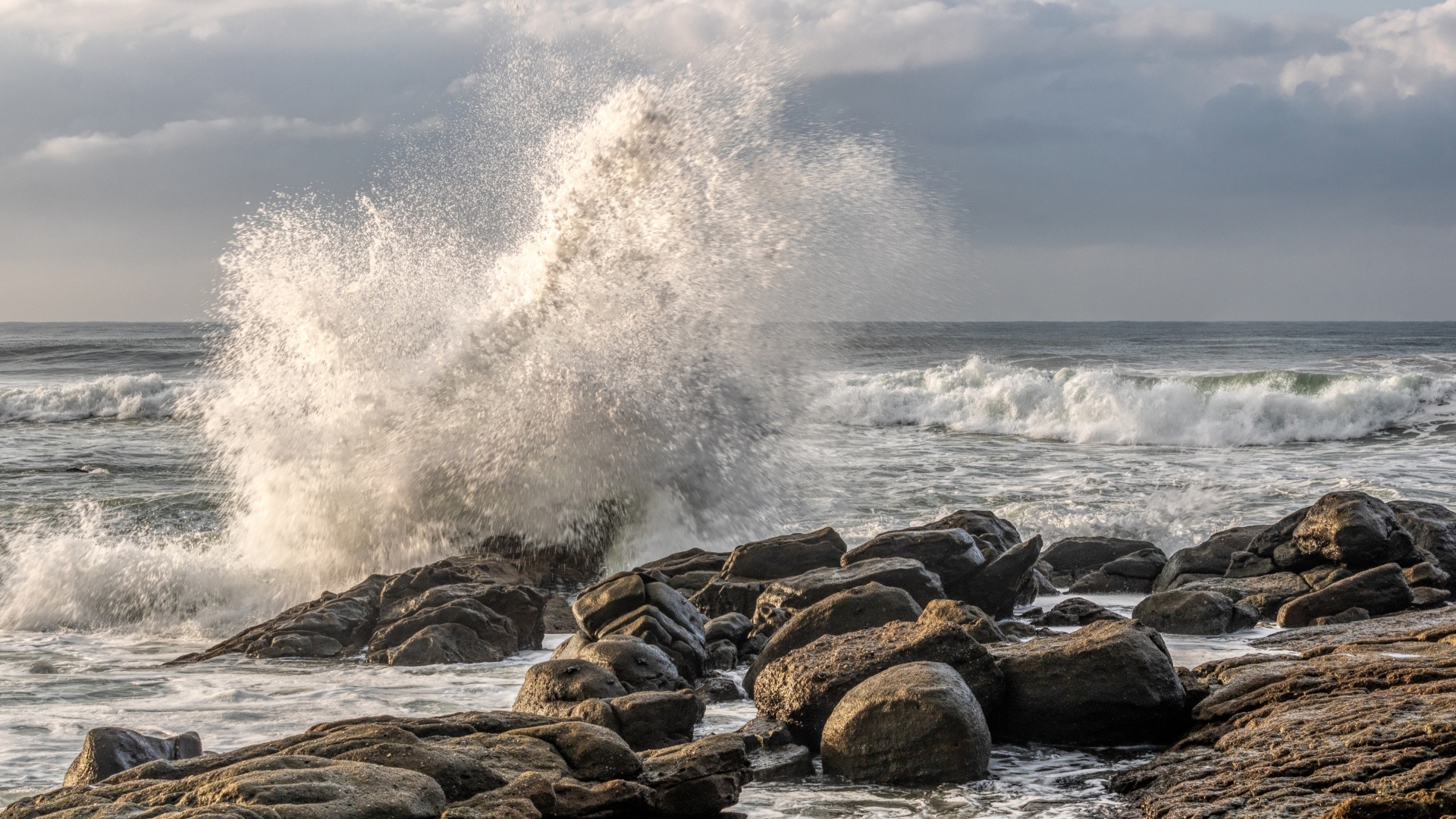 Морские волны бьются о камни на берегу