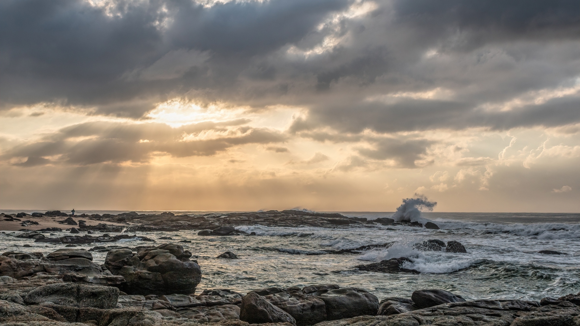 Лучи солнца пробиваются сквозь тучи над морем