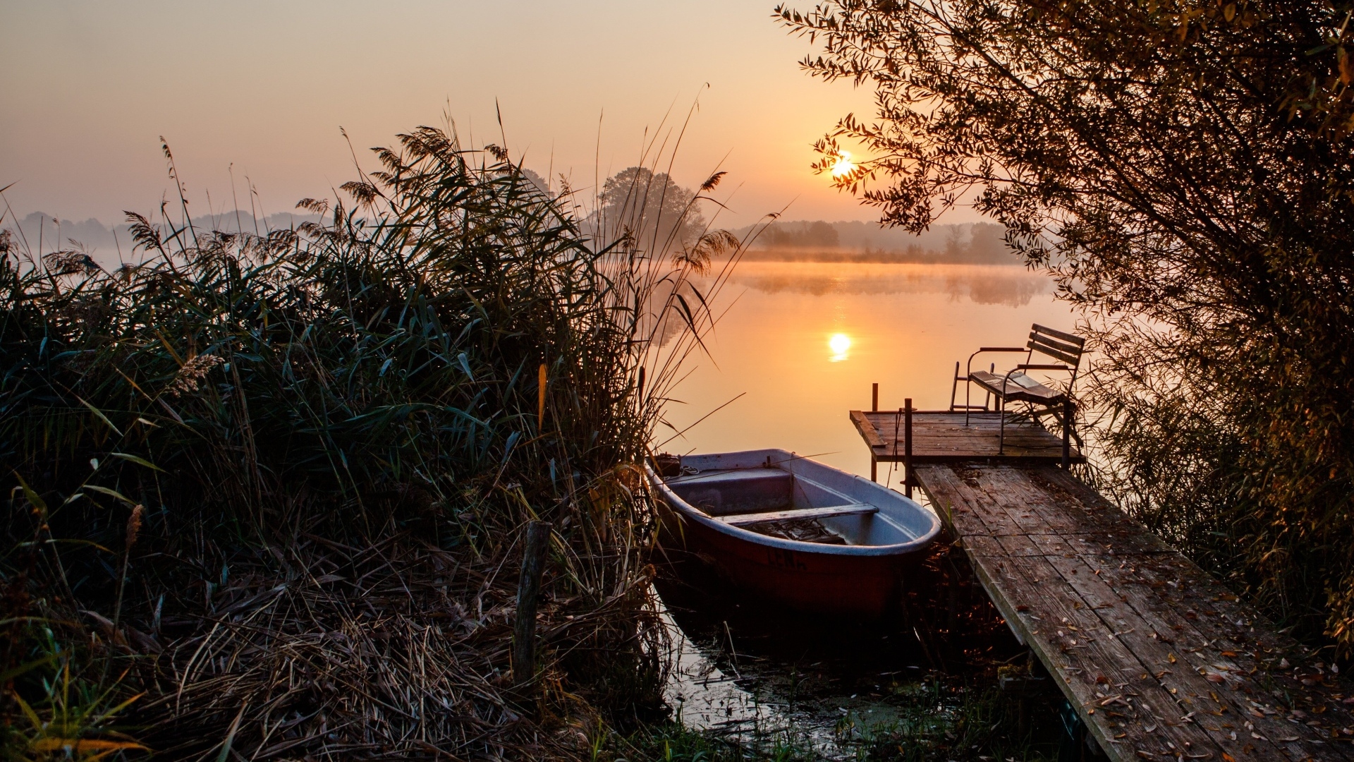 Лодка на берегу озера на закате 