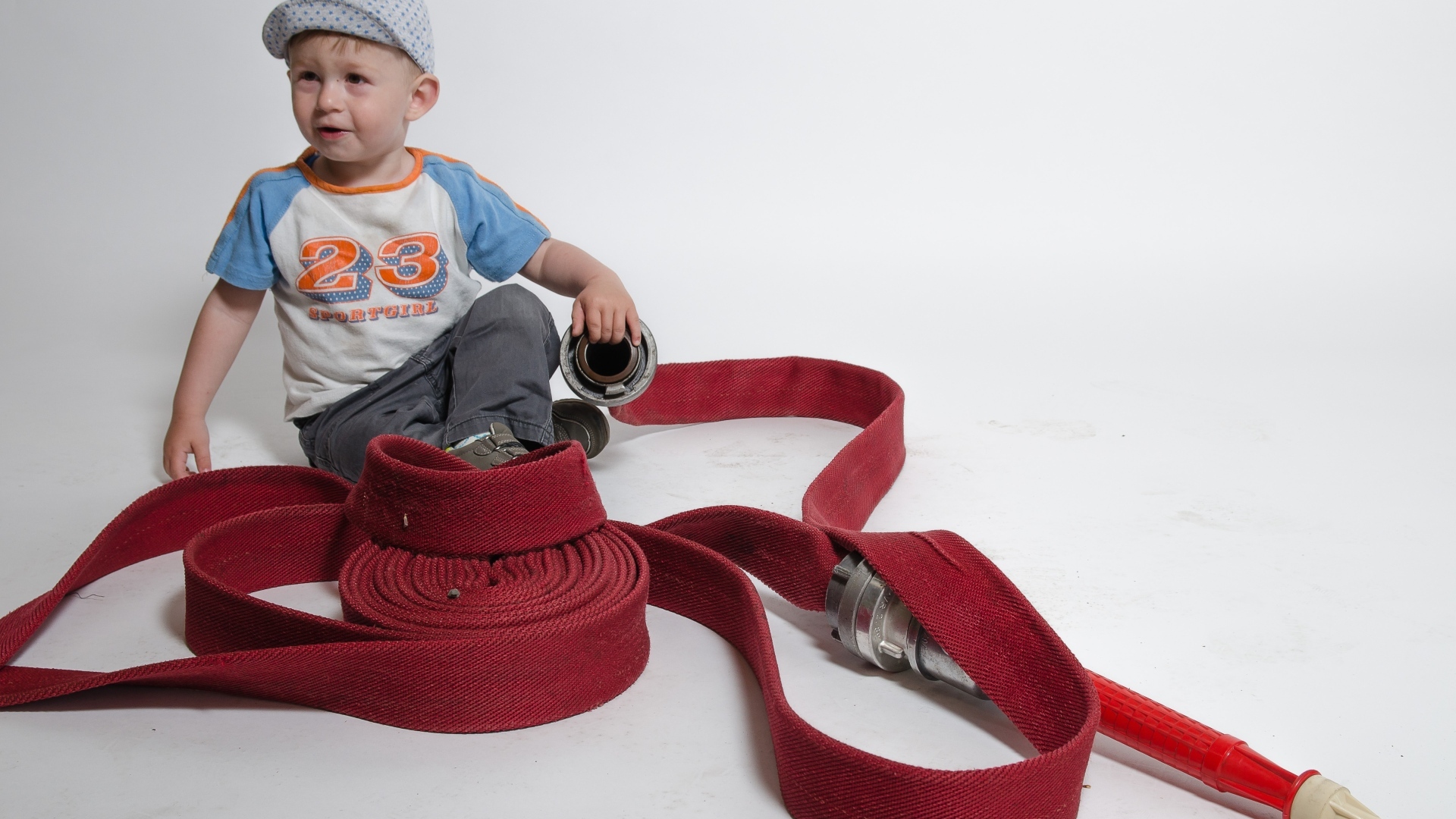 Мальчик с красным пожарным шлангом