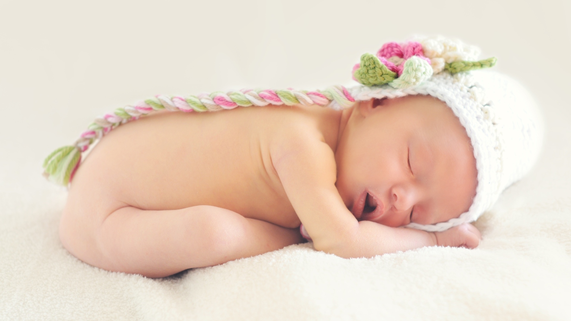 Нежный спящий ребенок в вязаной шапке 