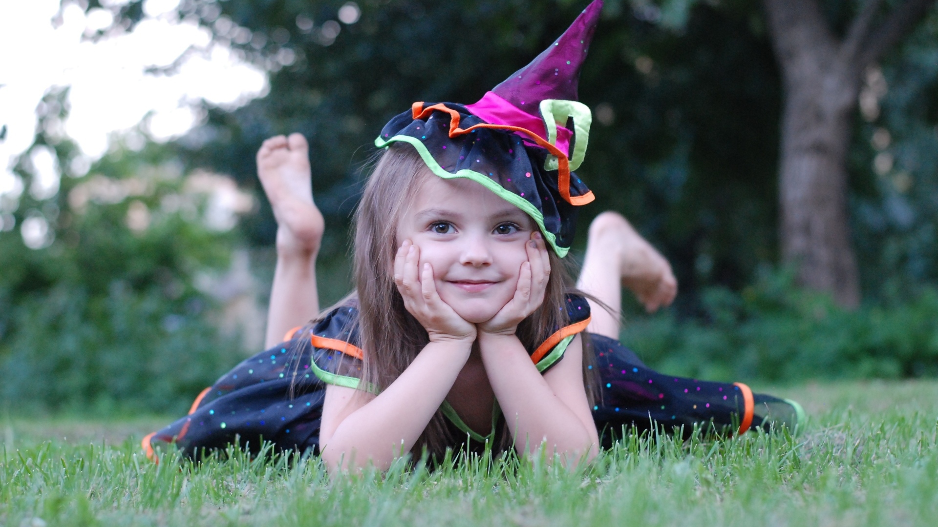 Девочка в костюме лежит на зеленой траве