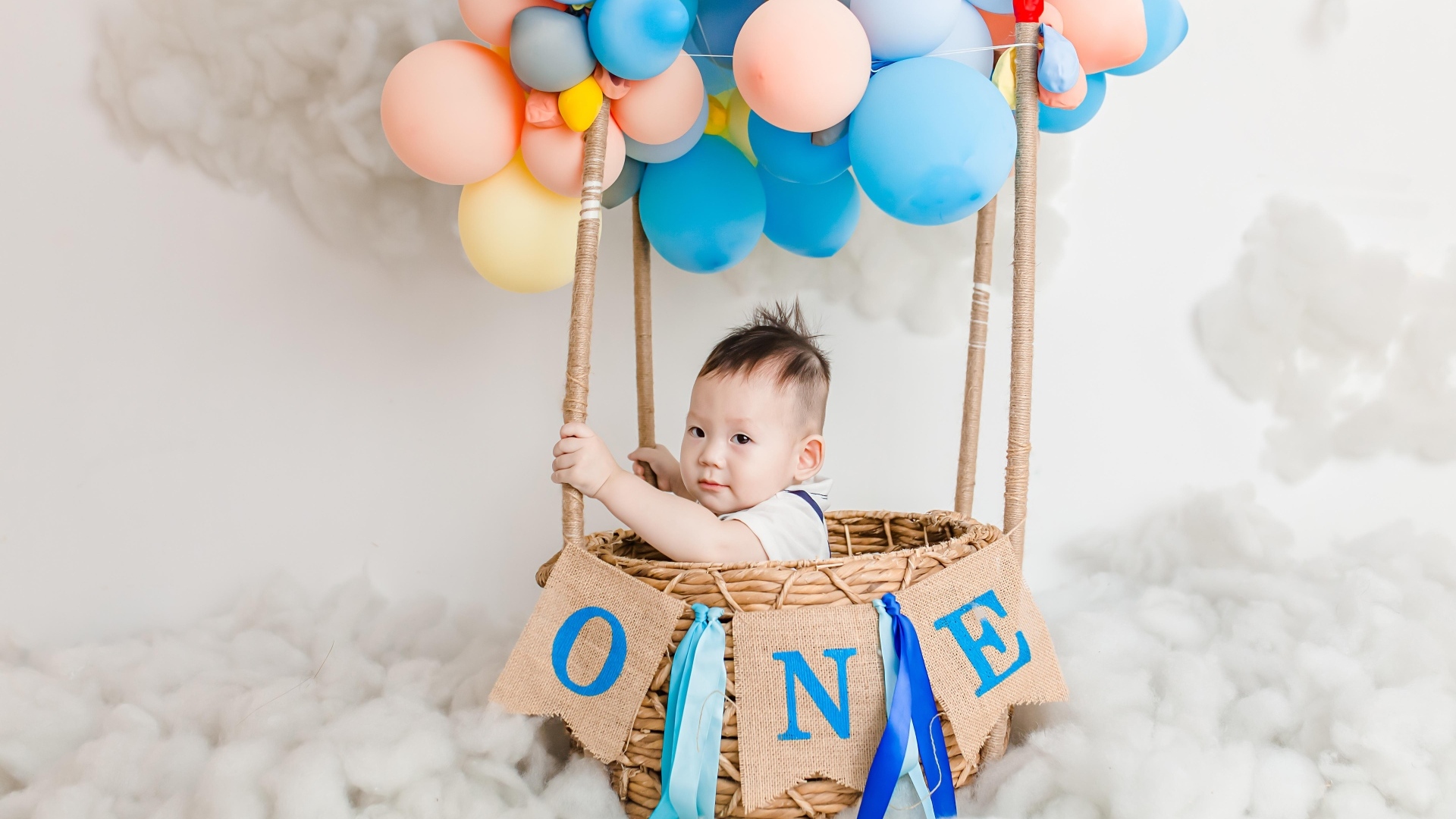 Маленький мальчик в корзине с воздушными шарами