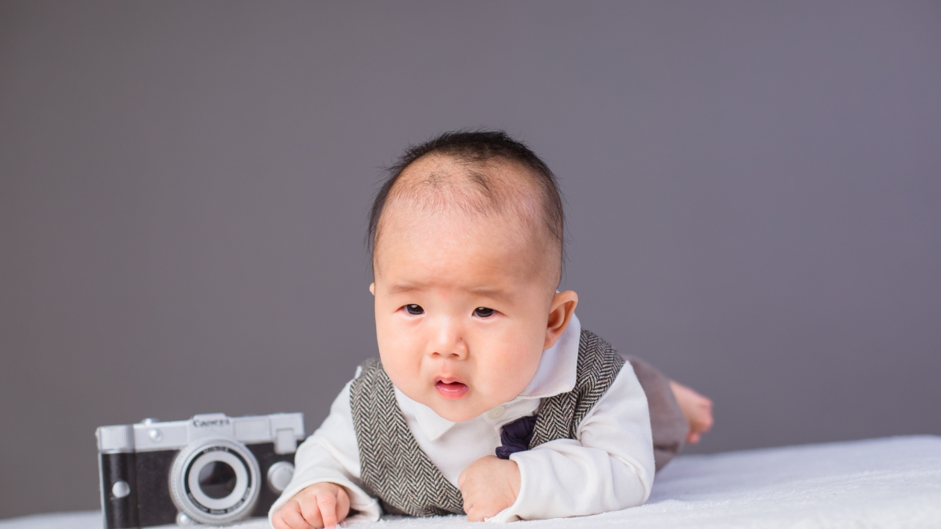 Маленький мальчик в костюме с фотоаппаратом