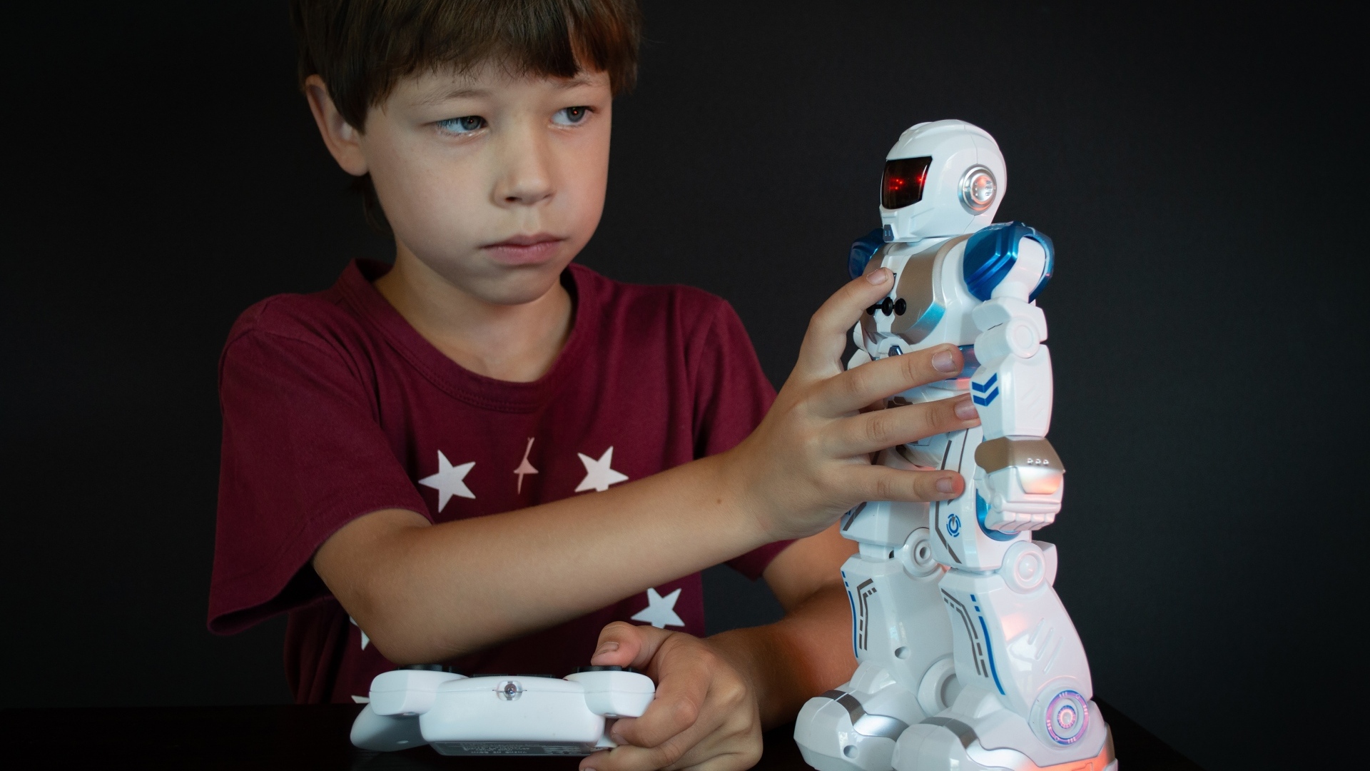 Маленький мальчик с роботом на черном фоне
