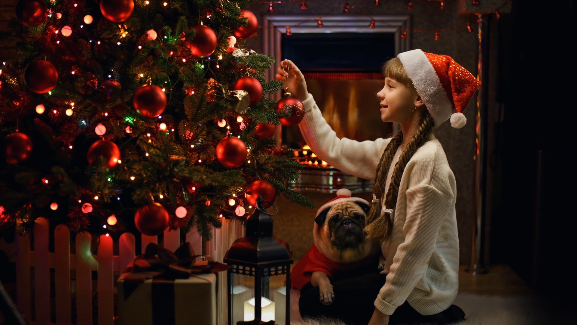 Маленькая девочка наряжает Рождественскую ель