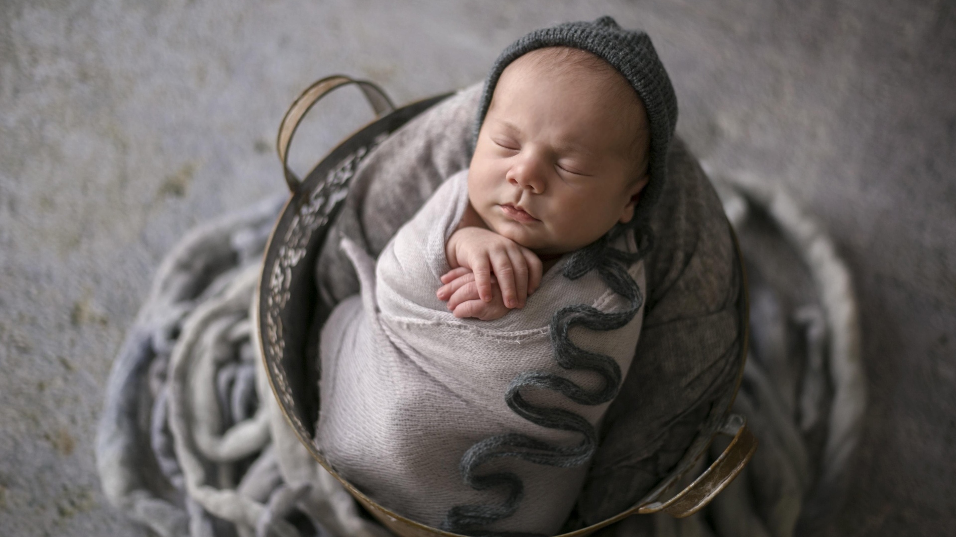 Маленький спящий новорожденный малыш в корзине