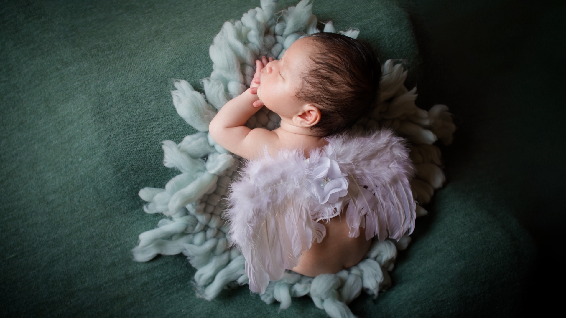 Спящий новорожденный малыш с крыльями ангела 