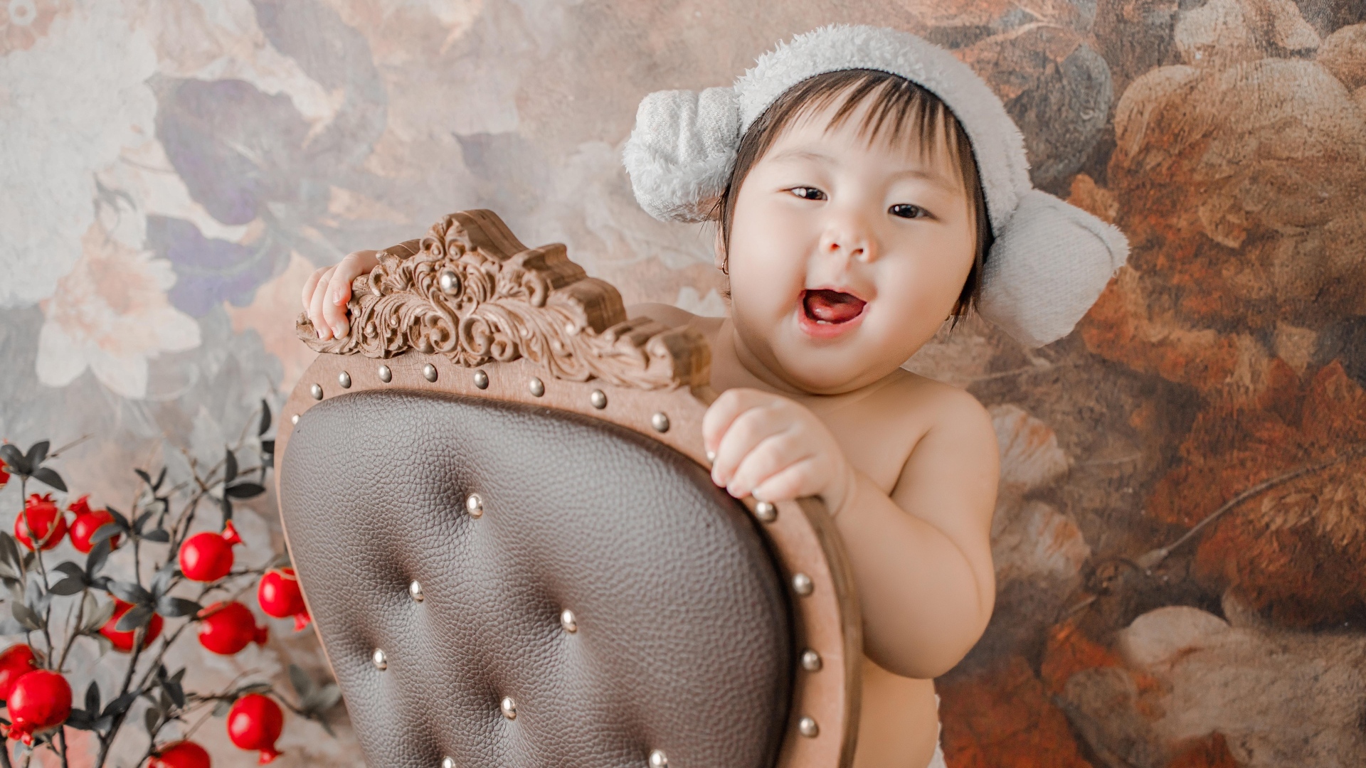 Улыбающийся ребенок азиат стоит у кресла