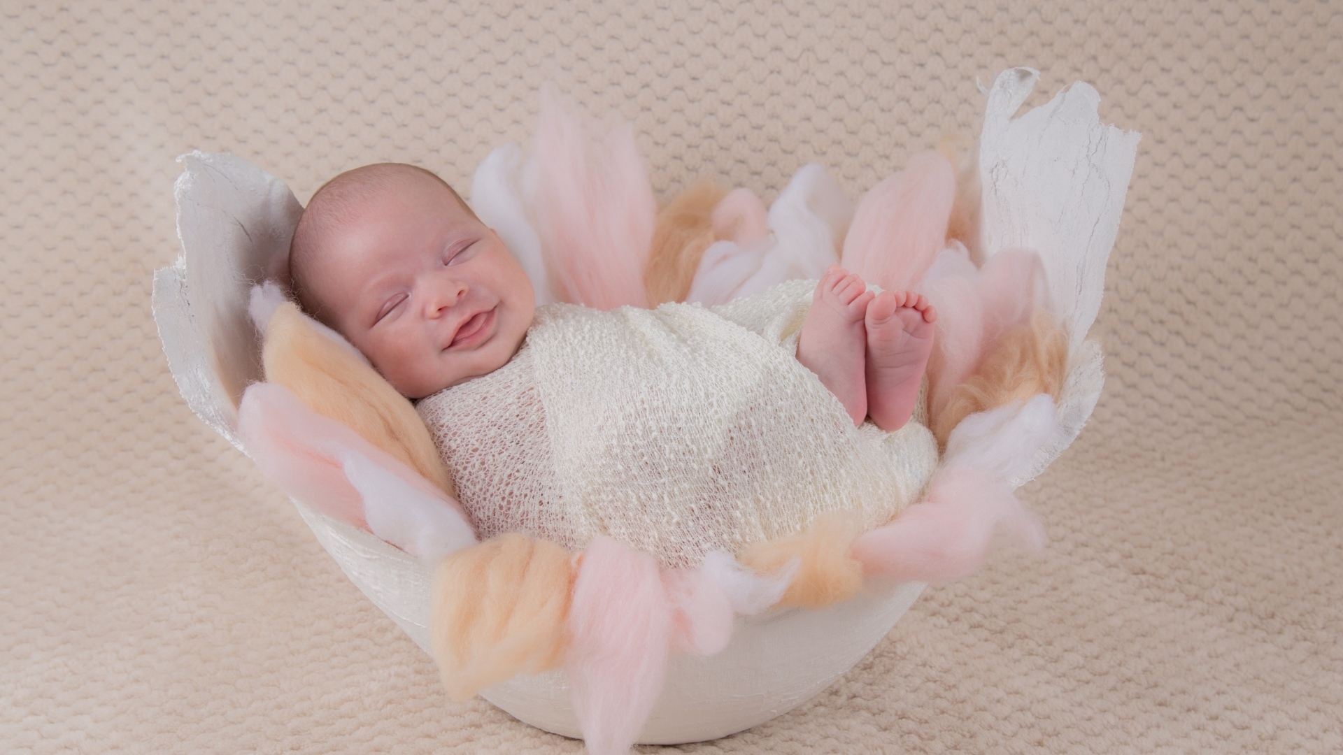 Улыбающийся спящий новорожденный малыш