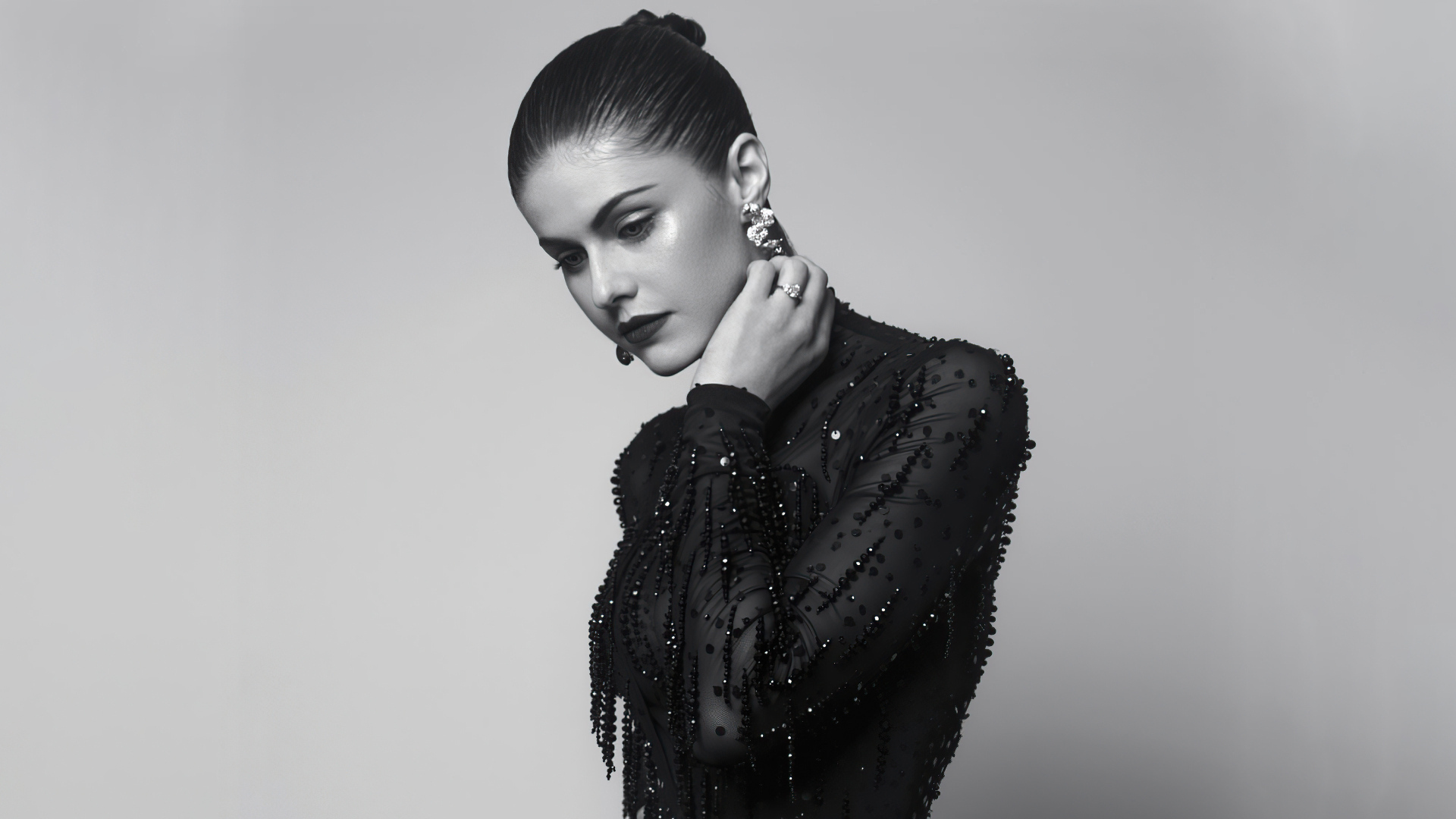 Актриса Александра Даддарио в черном платье на сером фоне