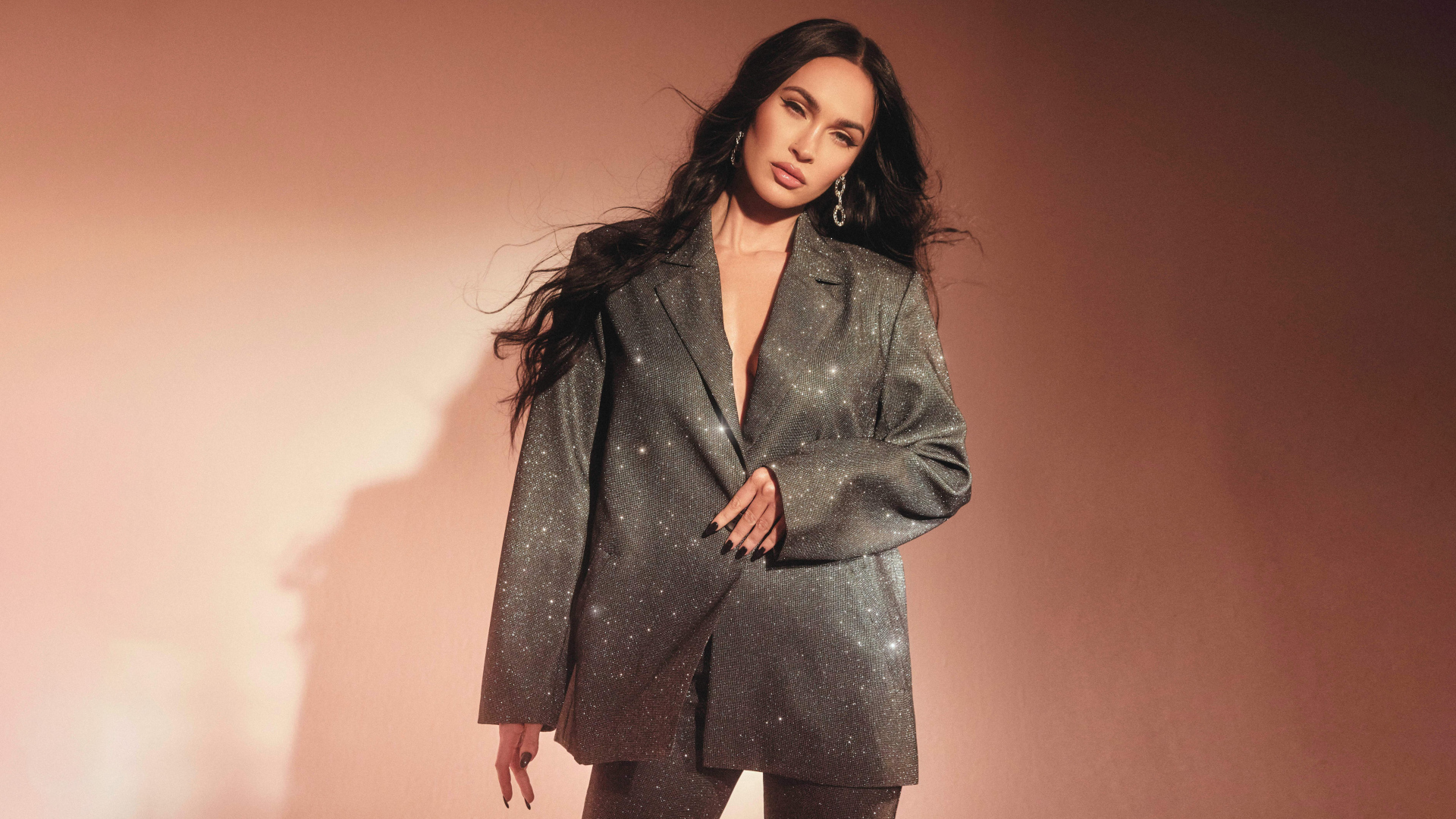 Актриса Меган Фокс в ярком костюме у стены