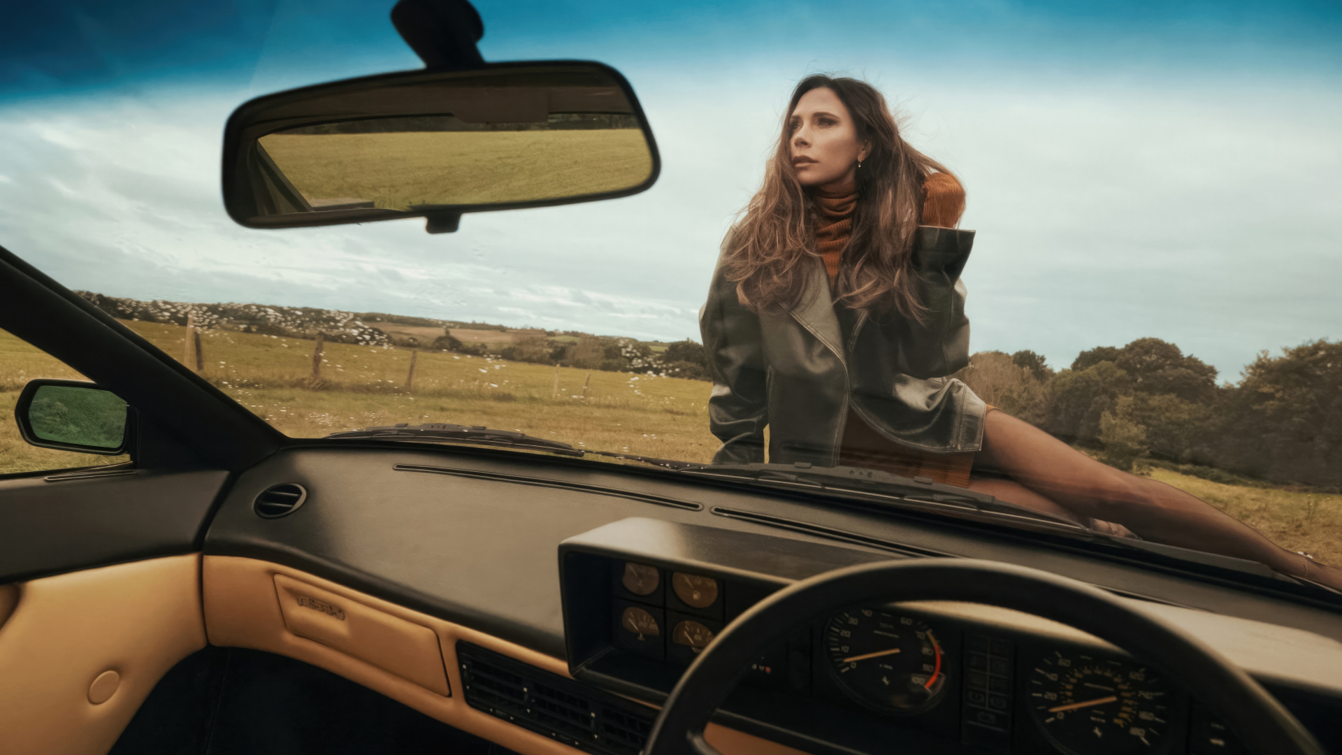 Красивая девушка Виктория Бекхэм сидит на машине