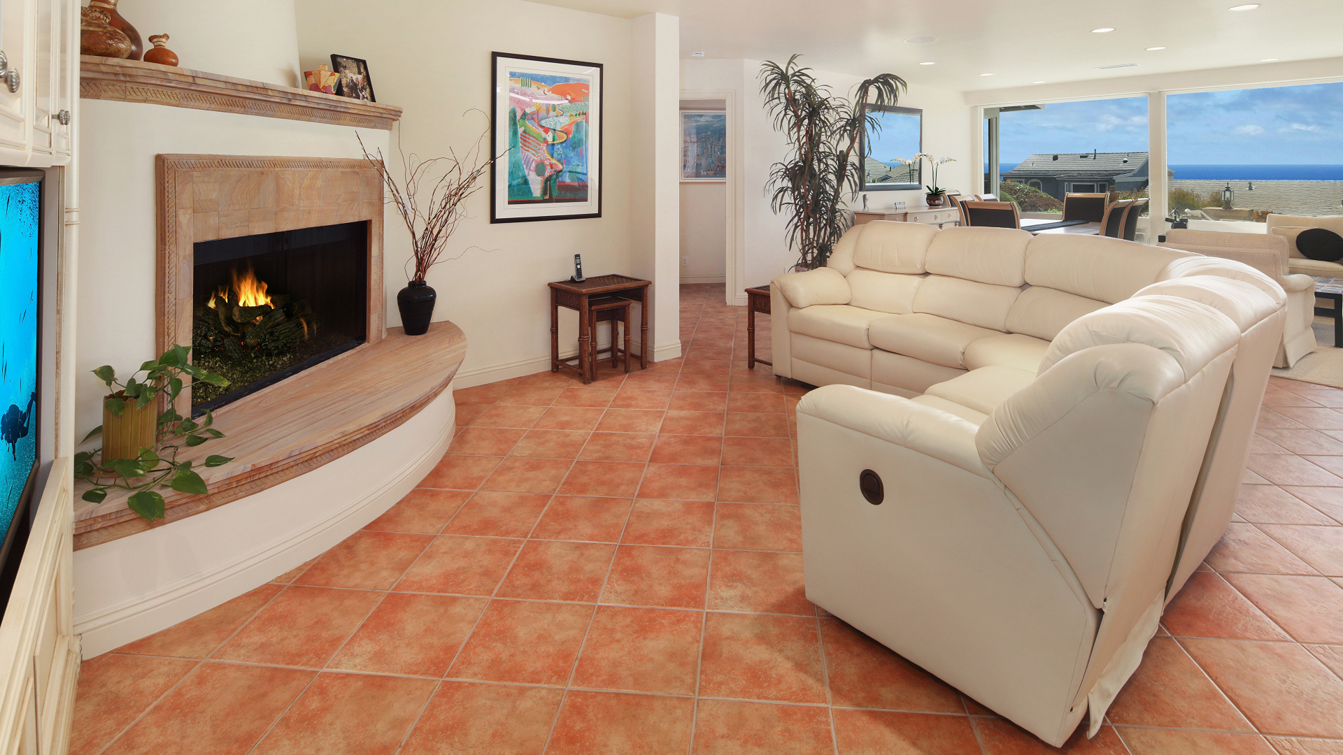 Красивый белый кожаный диван в гостиной с камином