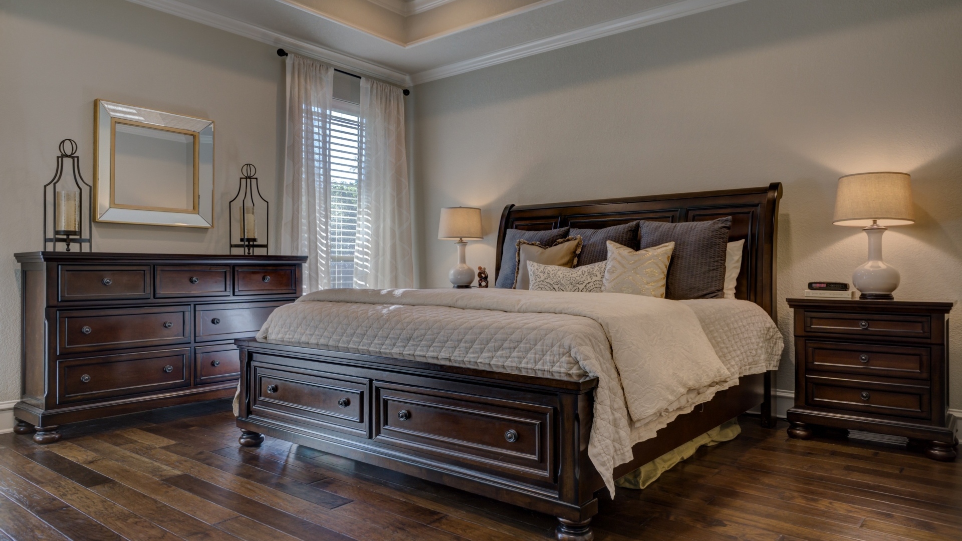 Дорогая деревянная кровать в спальной комнате