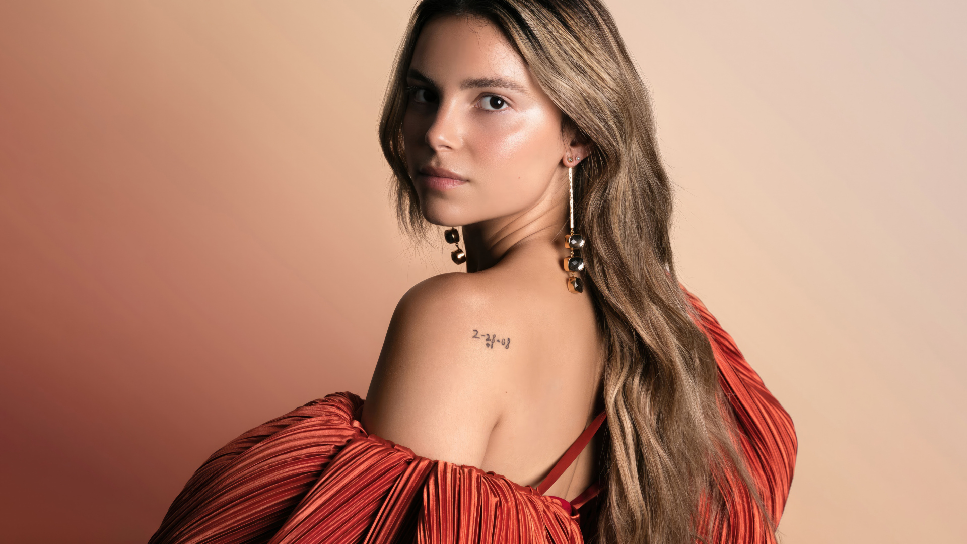 Стильная девушка актриса Инде Наварретт на розовом фоне