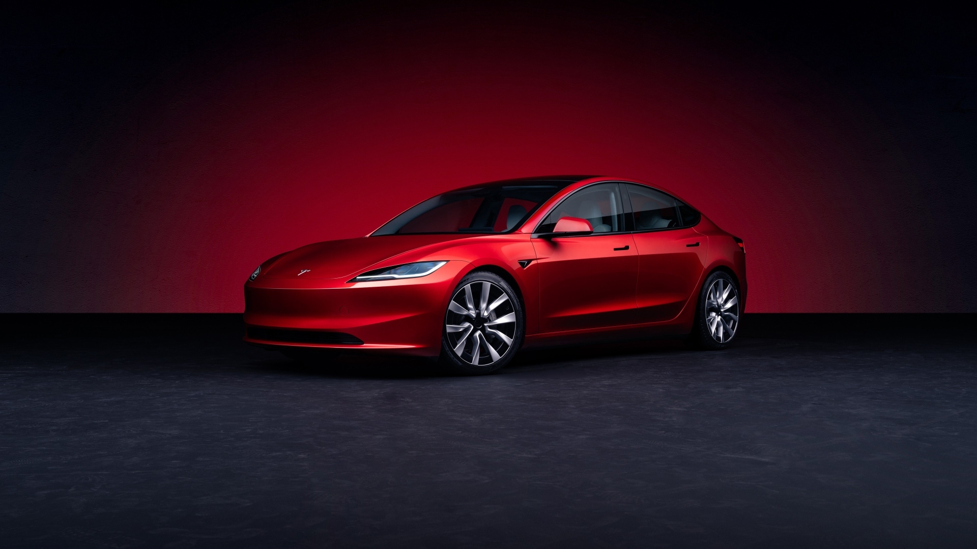 Автомобиль Tesla Model 3 2023 года на красном фоне