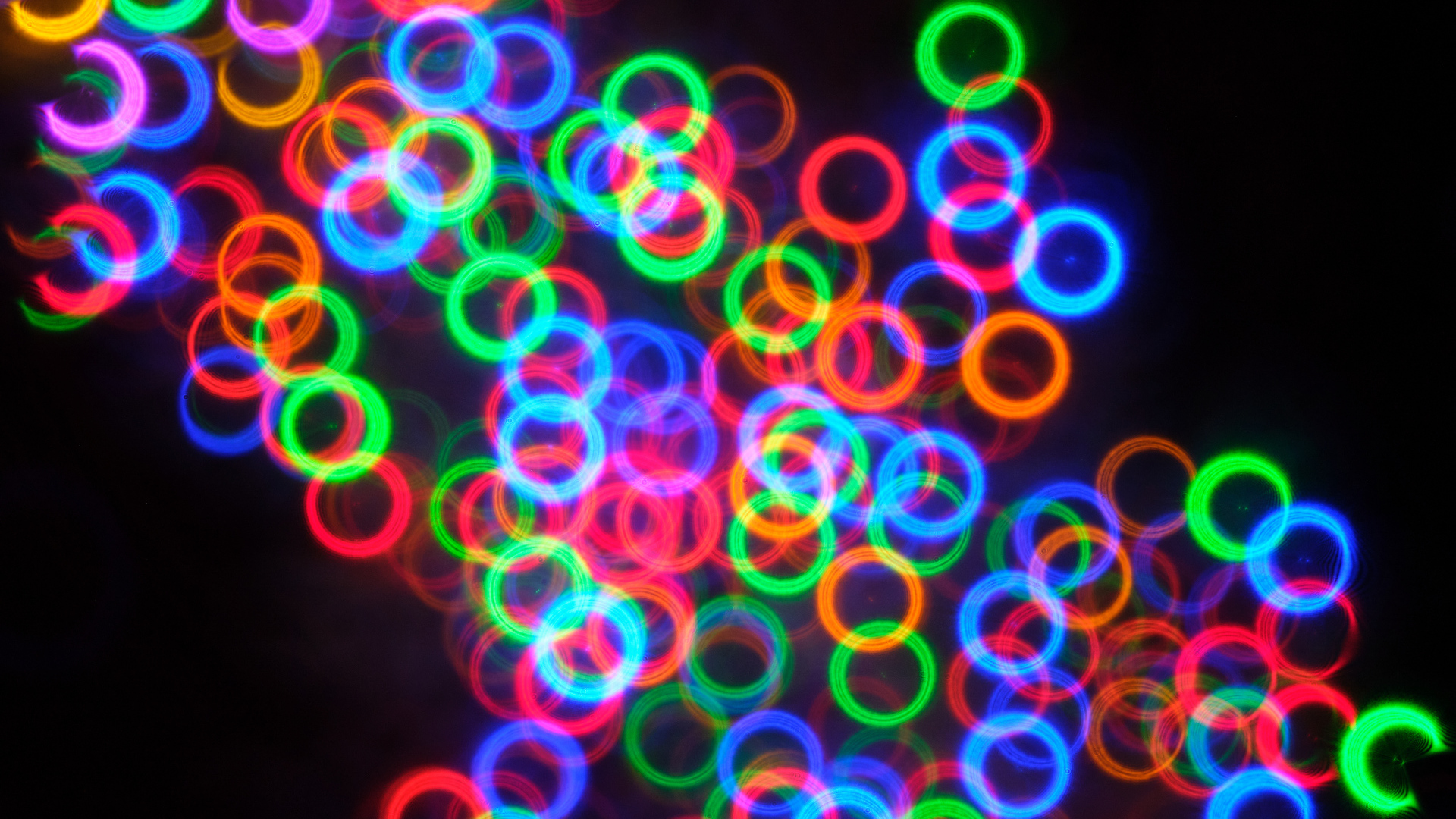 Разноцветные неоновые круги на черном фоне