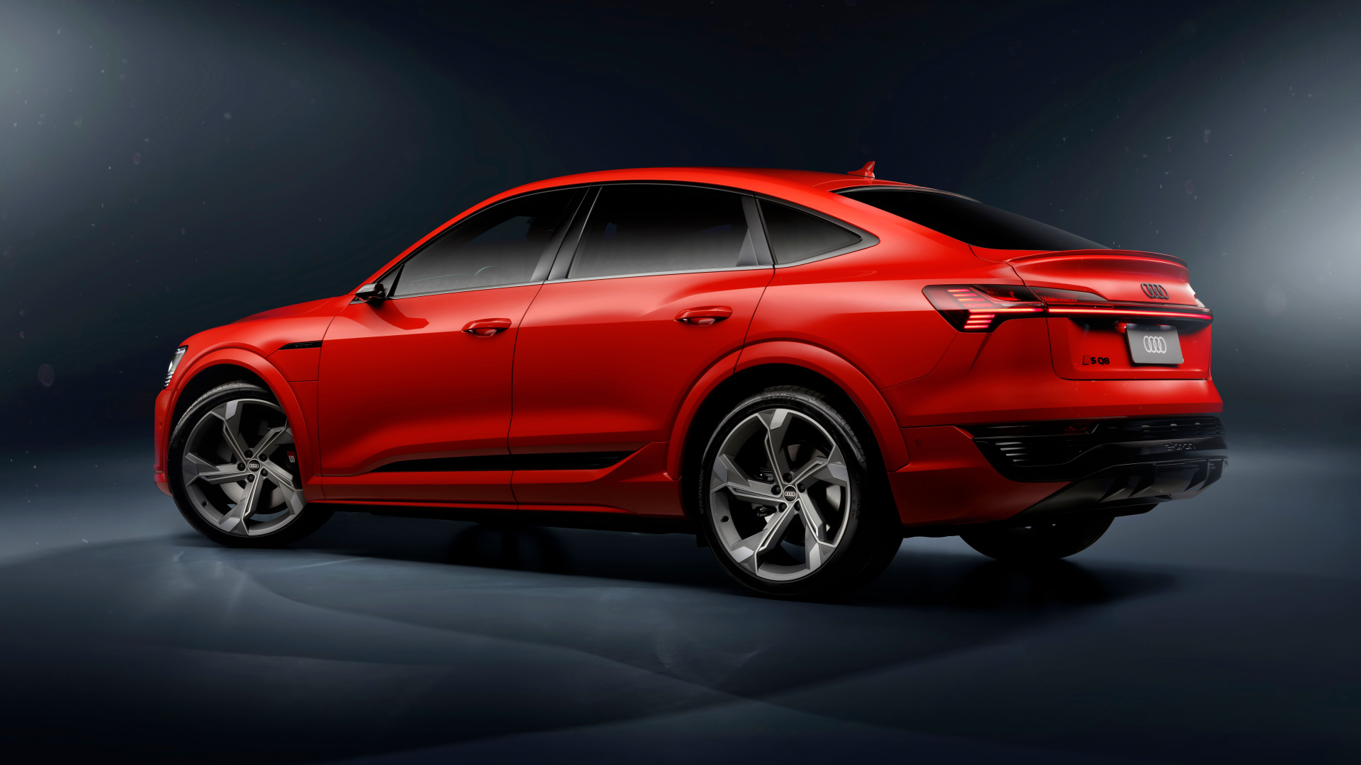 Вид сзади на красный автомобиль Audi SQ8 Sportback E-Tron Quattro 2024 года