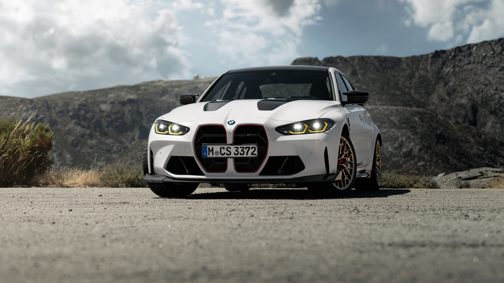 Белый автомобиль BMW M3 CS  на фоне гор